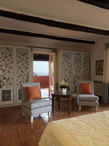 Zimmer mit dekorativen Schranktüren und Zugang zu Balkon mit Meerblick