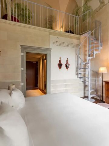 Zimmer mit Wendeltreppe und stilvoller Möblierung im Hotel Il Salviatino