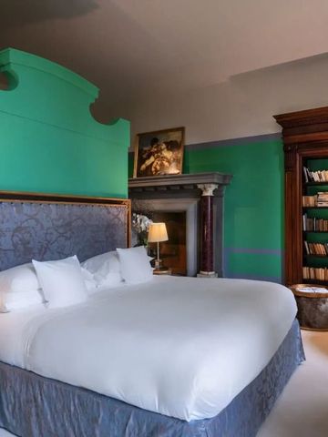 Elegantes Hotelzimmer mit großem Bett, Bücherregal und edlem Dekor