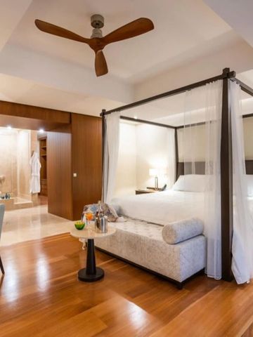 Geräumiges Zimmer mit stilvollem Himmelbett und warmer Beleuchtung