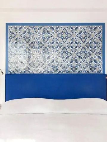 Elegantes Schlafzimmer mit blauem Kopfteil und weißer Bettwäsche