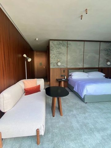 Ruhiges Hotelzimmer mit Holzelementen, Sofa und Doppelbett