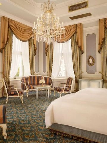 Luxuriöses Hotelzimmer mit opulentem Kronleuchter und eleganter Einrichtung.