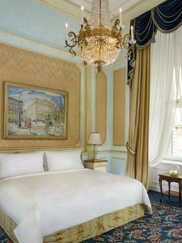 Opulentes Schlafzimmer mit dekorativem Kronleuchter im Hotel Imperial Wien