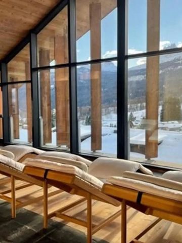 Sonnendurchflutete Lounge mit Panoramafenstern und Blick auf die Berge