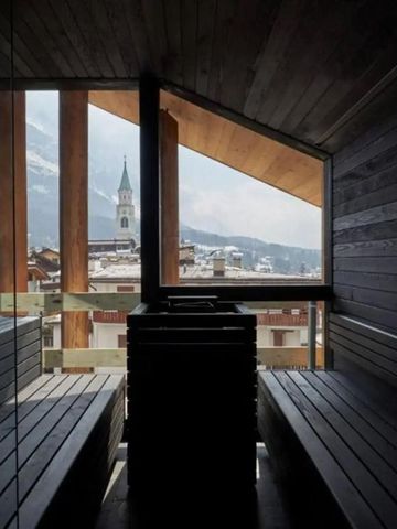 Panorama-Sauna mit Blick auf die Berge durch große Fenster.