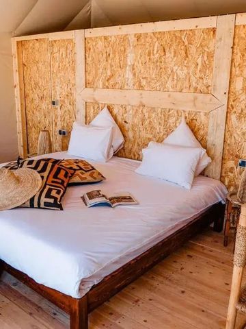 Lichtdurchflutetes Zelt mit großem Bett und schlichter, natürlicher Dekoration im Inara Camp.