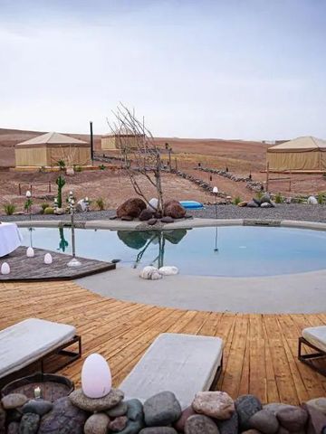 Luxuriöser Poolbereich mit Liegestühlen und Blick auf die Wüste