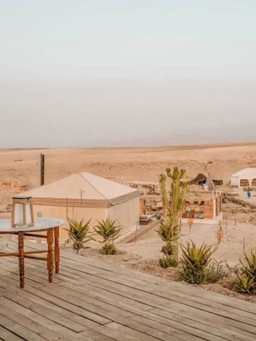 Blick von der Holzterrasse auf Wüstencamp mit Zelten