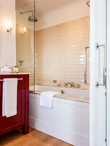 Elegantes Badezimmer mit weiß gefliesten Wänden und rotem Waschtisch