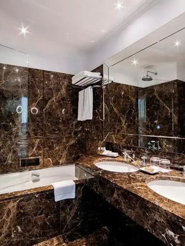 Luxuriöses Badezimmer mit Marmorwänden und Doppelwaschbecken