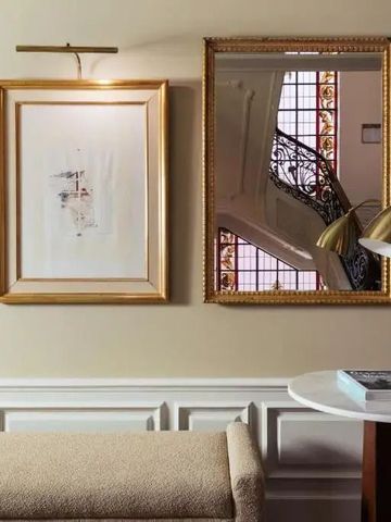 Elegantes Interieur mit goldgerahmten Bildern und stilvoller Beleuchtung