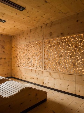 Holzverkleideter Ruheraum mit modernen Liegen