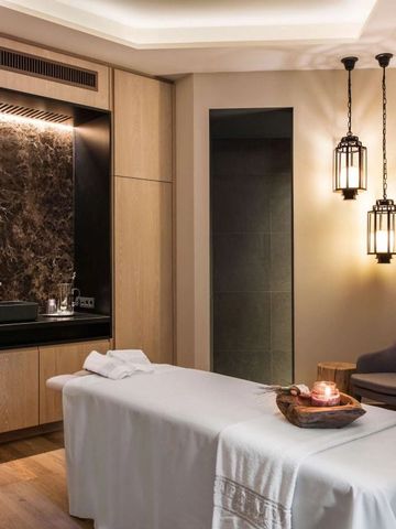Luxuriöser Behandlungsraum im Spa mit entspannender Beleuchtung und Massagetisch