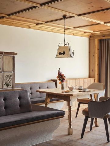 Gemütliche Stube mit Holzdecke, rustikalen Möbeln und traditionellem Kachelofen