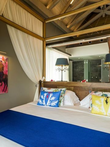 Komfortables Doppelzimmer mit blauer Bettdecke und stilvoller Beleuchtung