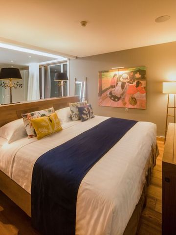 Gemütliches Schlafzimmer bei Nacht mit warmem Licht und Kunst an der Wand