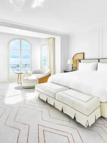 Helles Hotelzimmer im Carlton Cannes mit Meerblick und eleganter Einrichtung.