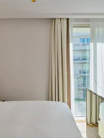 Helles Hotelzimmer mit großem Bett und Balkon