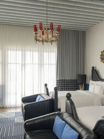 Moderner Raum mit zwei Betten und stilvollem Leuchter