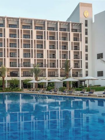 Moderner Hotelbau mit großem Außenpool und stilvollen Sonnenschirmen.