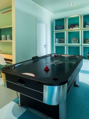 Spielraum mit Air-Hockey-Tisch und türkisfarbenen Wänden