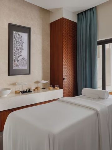 Luxuriöser Spa-Behandlungsraum mit Massageliege und Vorhängen