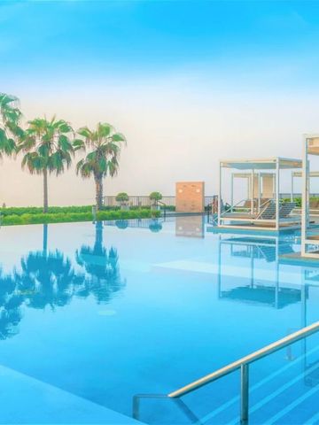 Infinity-Pool mit Palmen und Liegebetten im InterContinental Fujairah Resort