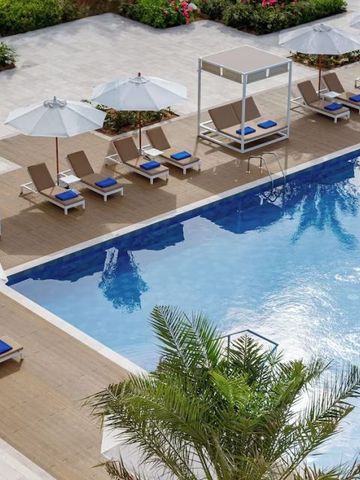 Luftaufnahme eines Pools mit Liegen und Sonnenschirmen im InterContinental Fujairah Resort
