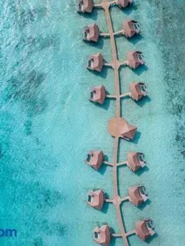 Villen auf Stelzen über türkisblauem Wasser in einer Luftaufnahme