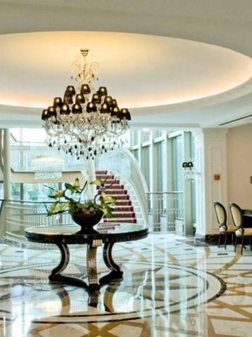 Prächtige Lobby mit großem Kronleuchter und Marmorboden im InterContinental Porto