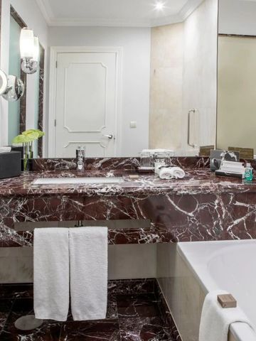 Luxuriöses Badezimmer mit Marmoroberflächen und integriertem Waschbecken