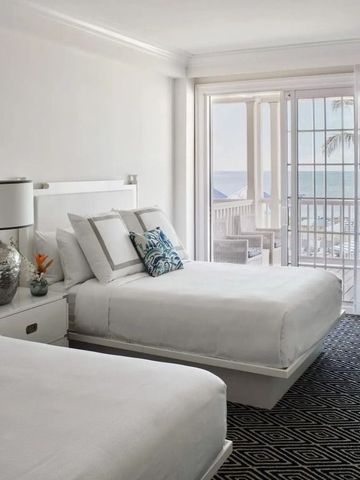 Modernes Hotelzimmer mit zwei Betten und Meerblick durch große Fenster