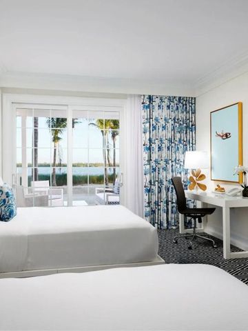 Moderne Suite mit Arbeitsbereich und gläsernen Türen zum Meerblick-Balkon