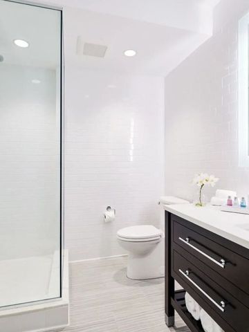 Geräumiges Badezimmer mit Glasdusche und eleganter Einrichtung.