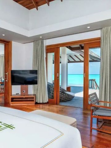 Modernes Zimmer mit Terrasse und Blick auf türkisfarbenes Wasser