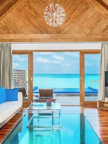 Luxuriöses Wohnzimmer mit Meerblick durch große Fenster und Holzakzenten