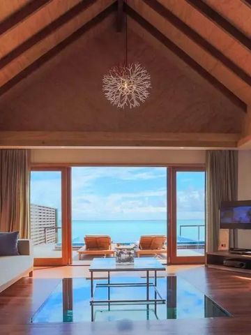 Gemütliches Wohnzimmer mit attraktiver Holzdecke und Meerblick