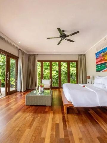 Großzügiges Schlafzimmer mit freiem Blick auf den Garten und edlen Holzböden