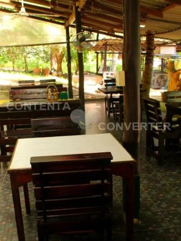 Rustikaler Essbereich mit Holztischen unter schattenspendendem Dach