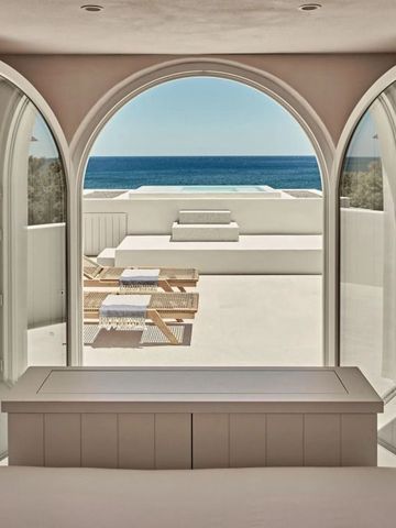 Luxuriöser Zimmerblick auf eine Terrasse mit Blick auf das Meer durch große Doppelglastüren.