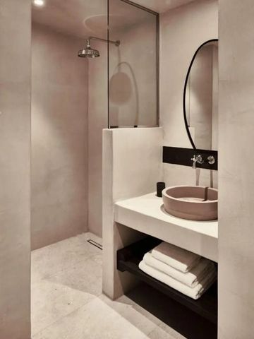 Modernes Badezimmer mit Regenwalddusche und eleganten Waschbecken im minimalistischen Design.