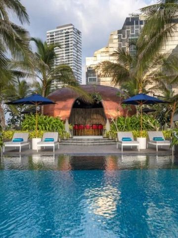 Luxuriöser Poolbereich mit Liegestühlen und tropischen Pflanzen