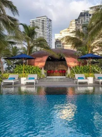 Eleganter Pool mit Liegestühlen und tropischer Umgebung