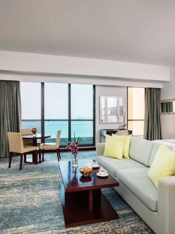 Luxussuite mit Essbereich und Panoramafenstern mit Meerblick