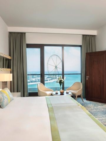Elegantes Hotelzimmer mit Blick aufs Meer und gemütlichen Sitzgelegenheiten