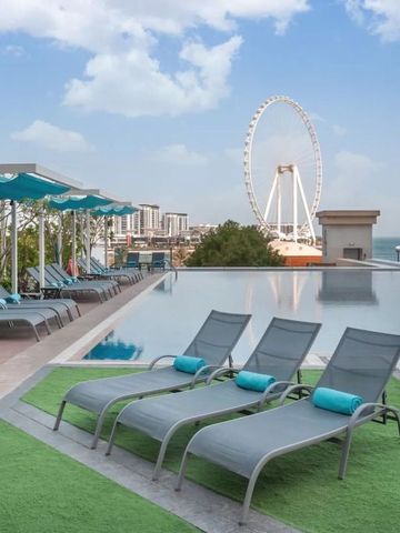 Sonnenliegen am Infinity-Pool mit Blick auf ein Riesenrad