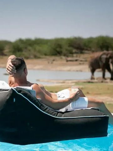 Entspannt am Pool mit Aussicht auf Elefanten in natürlicher Umgebung