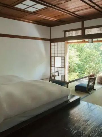 Traditionelles japanisches Zimmer mit Tatami-Matten und Blick auf den Garten