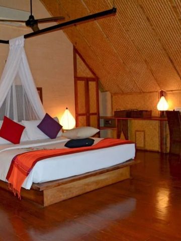 Luxuriöses Schlafzimmer unter einem hohen, hölzernen Gewölbedach